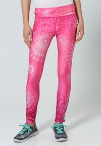 Leggings rosa con un motivo floreale vorticoso, realizzati in materiale elasticizzato con una texture liscia. Design affusolato e vita alta.