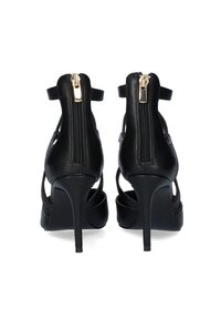 Sandalias de tacón alto negras con un acabado de cuero brillante, que cuentan con un cierre de cremallera en la parte posterior y un diseño recortado para ventilación.