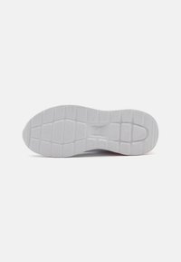 Semelle de sneaker blanche avec une surface en caoutchouc texturée présentant un motif rectangulaire, offrant adhérence et stabilité. Détail de marque discret inclus.