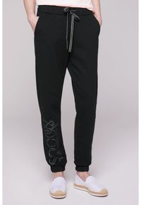 Soccx MIT GLITTER PRINT - Pantalones deportivos - black