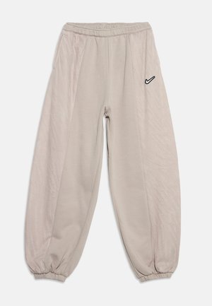 Ανοιχτό μπεζ αθλητικές φόρμες Nike με ελαστική μέση και μανσέτες, πλαϊνές τσέπες και μικρό μαύρο λογότυπο Nike Swoosh στο δεξί μηρό.