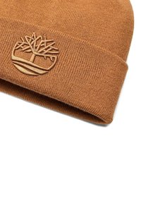 Berretto lavorato a maglia marrone realizzato in materiale morbido, con un logo ad albero ricamato. Il design presenta un orlo ripiegato per un ulteriore dettaglio.