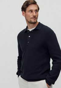 Laivastonsininen röpelöitu neulepolo-sweater, jossa on nappikaulus ja lyhyt kaulus, pitkät hihat ja kapea helma.
