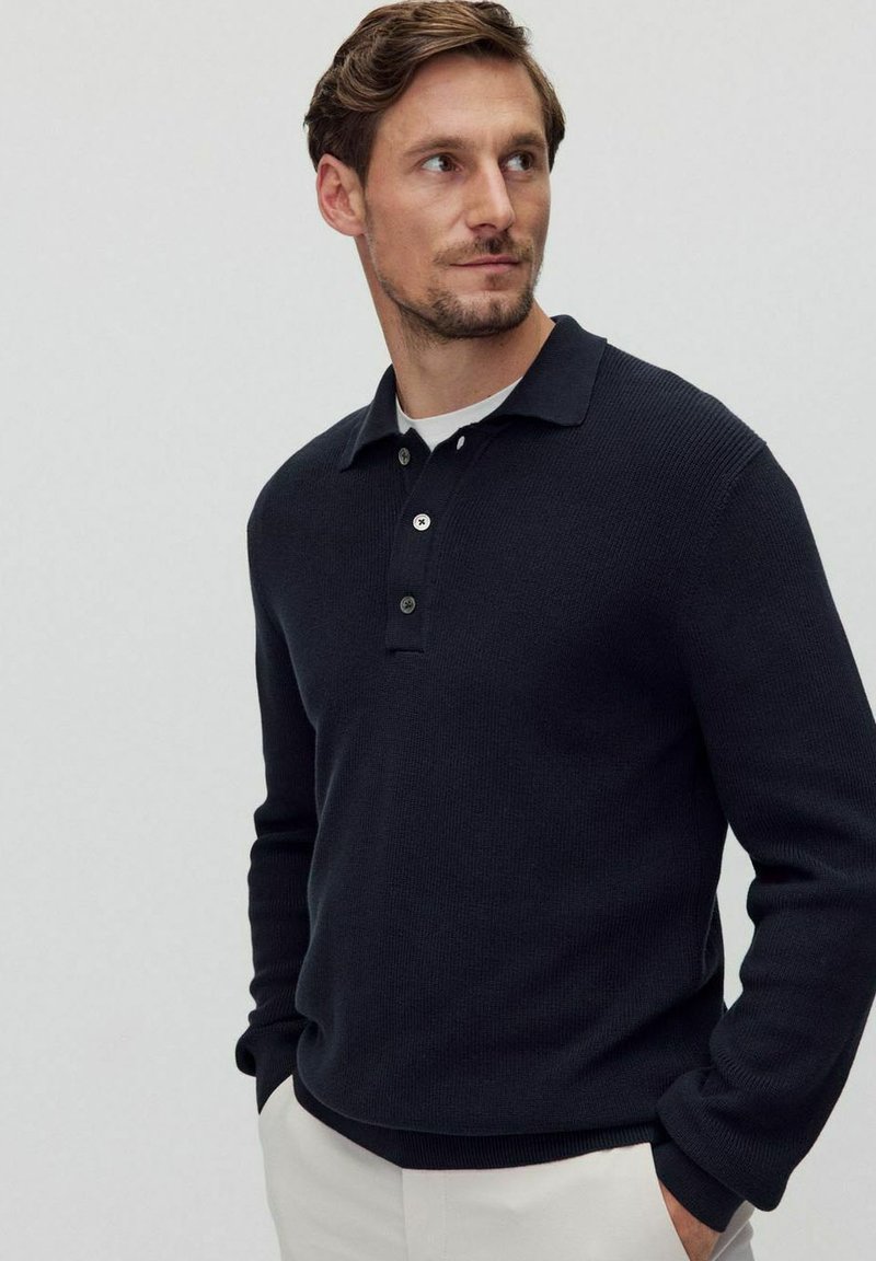 Laivastonsininen röpelöitu neulepolo-sweater, jossa on nappikaulus ja lyhyt kaulus, pitkät hihat ja kapea helma.