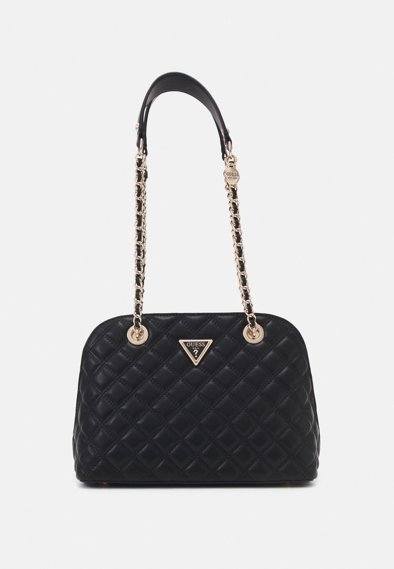 Sac à main noir matelassé avec des anses en chaîne dorée et une plaque triangulaire avec le logo Guess au centre avant.