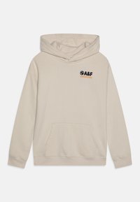 Beige hoodie lavet af blødt materiale. Har en kengurulomme, justerbar hætte og et frontlogo i sort og orange.