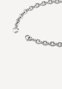 Bracciale in argento con grandi anelli, charm a forma di cuore inciso con la scritta "GUESS" e chiusura a gancio sicura. Texture liscia, finitura lucida.