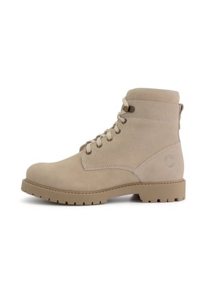 Beige suède enkellaars met vetersluiting, ronde neus en een getextureerde rubberen zool. Voorzien van een aantreklipje en logo-detail op de hak.