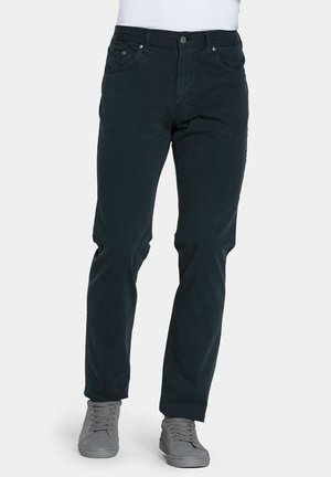 Chinos blu scuro a vestibilità slim, realizzati in cotone misto. Dotati di tasche anteriori, chiusura con bottone e passanti per cintura. Abbinati a sneaker grigie.