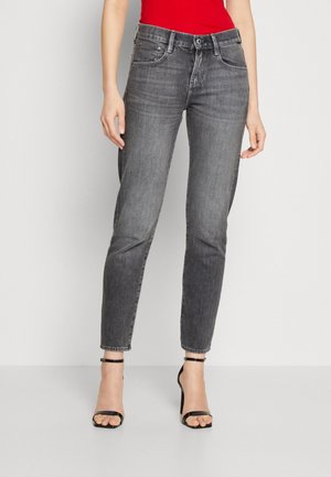 Gray denim jeans with a slim fit, five pockets, belt loops, and a slightly faded texture. Paired with black strappy high heels.