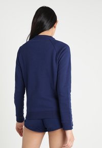 Sweatshirt bleu marine en tissu doux, doté d'un ourlet et de poignets côtelés, avec des manches raglan et un dos uni.