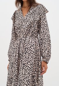 Leopardskottklänning i mjukt tyg, med V-ringning, puffärmar och elastisk midja för en figursydd passform.