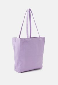 Sac fourre-tout en toile violet avec deux bretelles, de forme rectangulaire, texture lisse et détails de couture minimalistes. Idéal pour un usage quotidien.