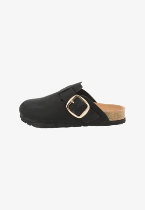 Black clog made of suede with a gold-tone buckle and a cork footbed. The design features an open back and a textured sole.