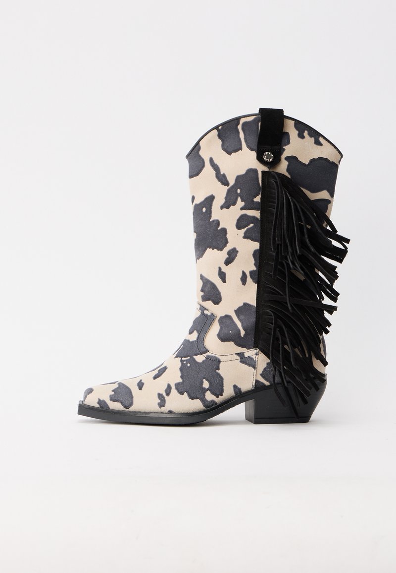 Cow-print mid-calf cowboy boot with black fringe detailing along the side and a low block heel on a white background.