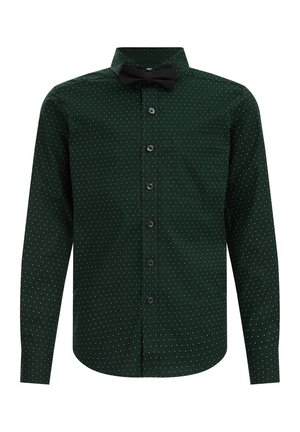 Camisa de manga larga verde oscuro con botones, pequeños lunares blancos, bolsillo delantero y una pajarita negra en el cuello.