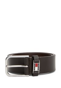 Cinturón de cuero marrón con una hebilla de metal plateado. Presenta un acento de logo cerca de la hebilla en rojo, blanco y azul. Textura suave, diseño clásico.