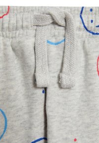 Graue Jogginghose im Detail mit einem Zugband mit strukturiertem Finish, verziert mit bunten Smileys in Rot und Blau.