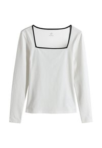 Haut blanc à manches longues avec un col carré, orné d'un galon contrastant noir le long du col. Confectionné en coton lisse.