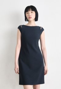Dark navy bodycon dress with short sleeves, featuring cut-outs on the shoulders. Smooth texture and sleek design enhance the silhouette.