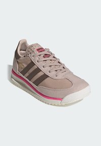 Svjetloružičasta sportska tenisica od brušene kože i mrežastog materijala, sadrži smeđe pruge, teksturiranu petu i ružičasti naglasak na srednjem potplatu.