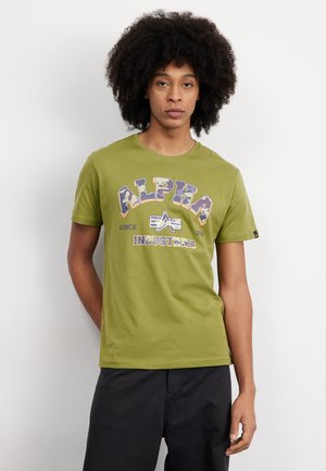 Olive green cotton t-shirt featuring front printed logo "ALPHA INDUSTRIES" in purple and yellow, round neckline, and short sleeves.