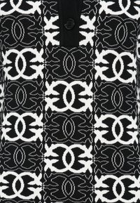 O tecido tricotado em preto e branco apresenta um padrão simétrico com formas orgânicas e um fecho central de botão.