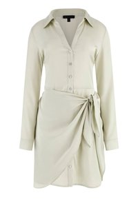 Beige pitkähihaineen paitamekko, jossa on napit edessä, kaulus ja vyötäröllä kietoutuva soljettiedetail.