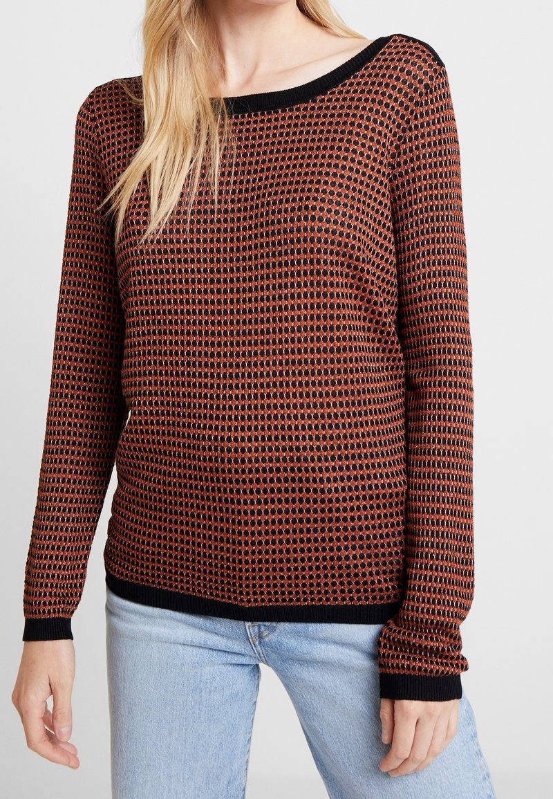 Ein gestrickter Pullover in Rot und Schwarz mit einem strukturierten Muster, rundem Halsausschnitt und langen Ärmeln. Verfügt über einen schwarzen gerippten Saum und Bündchen.