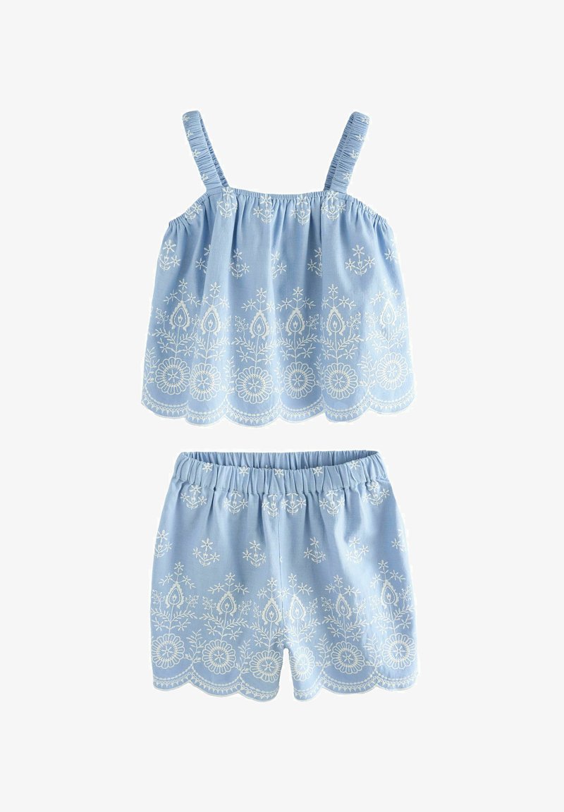 Ensemble débardeur bleu clair et short avec broderie florale blanche et bords festonnés.