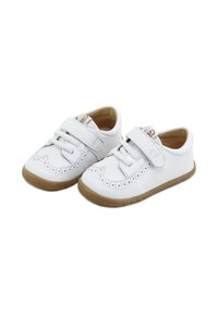 Zapatos de cuero blanco con diseño perforado, correa de Velcro y suela de goma marrón. Forma redondeada con costuras decorativas.