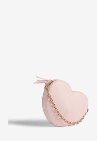 Srdcovitá ružová taška vyrobená z hladkej kože, so zipsovým uzávery, reťazovou rukoväťou a dekoratívnymi strapcami na vrchu.