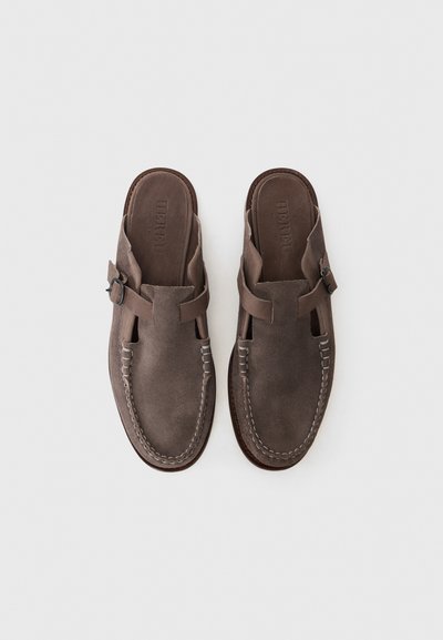 Scarpe slip-on in suede marrone con design a ritaglio e fibbia laterale. Presentano cuciture a contrasto e un'intelaiatura a punta arrotondata.