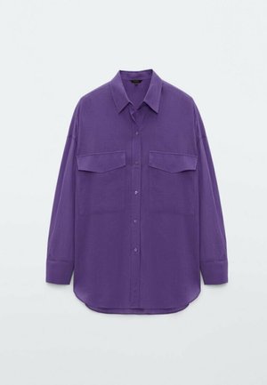 Purple button-up shirt with a classic collar, long sleeves, two front pockets, and a relaxed fit. Made from a smooth, textured fabric.