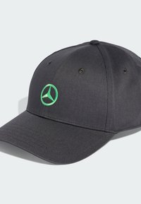 Svart basebollkeps i texturerat tyg med en grön broderad Mercedes-Benz-logotyp på framsidan och ventilationshål.