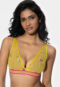 Żółty przezroczysty stanik o głębokim dekolcie, zdobiony kolorową haftowaną florą oraz różowo-złotym paskiem na dole.