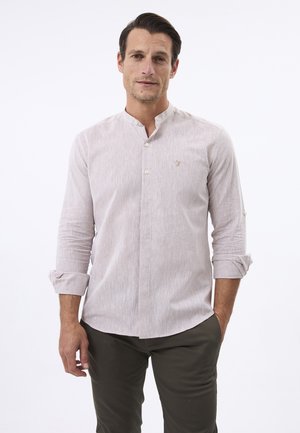 Lichtbeige button-up shirt met een bandkraag, lange mouwen opgerold, en een subtiele textuur. Bevat een klein logo op de borst.