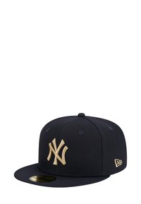 Casquette bleu marine avec un logo New York Yankees doré en relief. Fabriquée en tissu structuré avec une visière plate et des œillets de ventilation.
