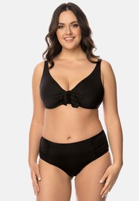 Set bikini nero con top sagomato e fiocco centrale, e slip a vita alta con arricciature laterali. Tessuto liscio e elastico.