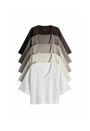 Fem V-hals striktoppe med korte ærmer og brystlommer, arrangeret som en vifte, i hvid, creme, lysegrå, mørkegrå og sort.