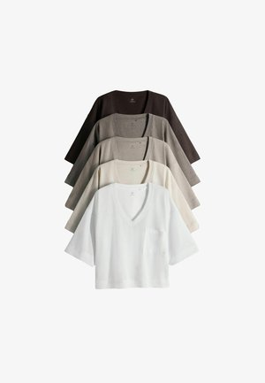 Fem V-hals striktoppe med korte ærmer og brystlommer, arrangeret som en vifte, i hvid, creme, lysegrå, mørkegrå og sort.