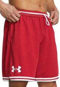 Pantalones cortos deportivos rojos con acentos blancos, que cuentan con una cinturilla elástica con cordón, bolsillos laterales y un logo en la parte inferior de la pierna izquierda.