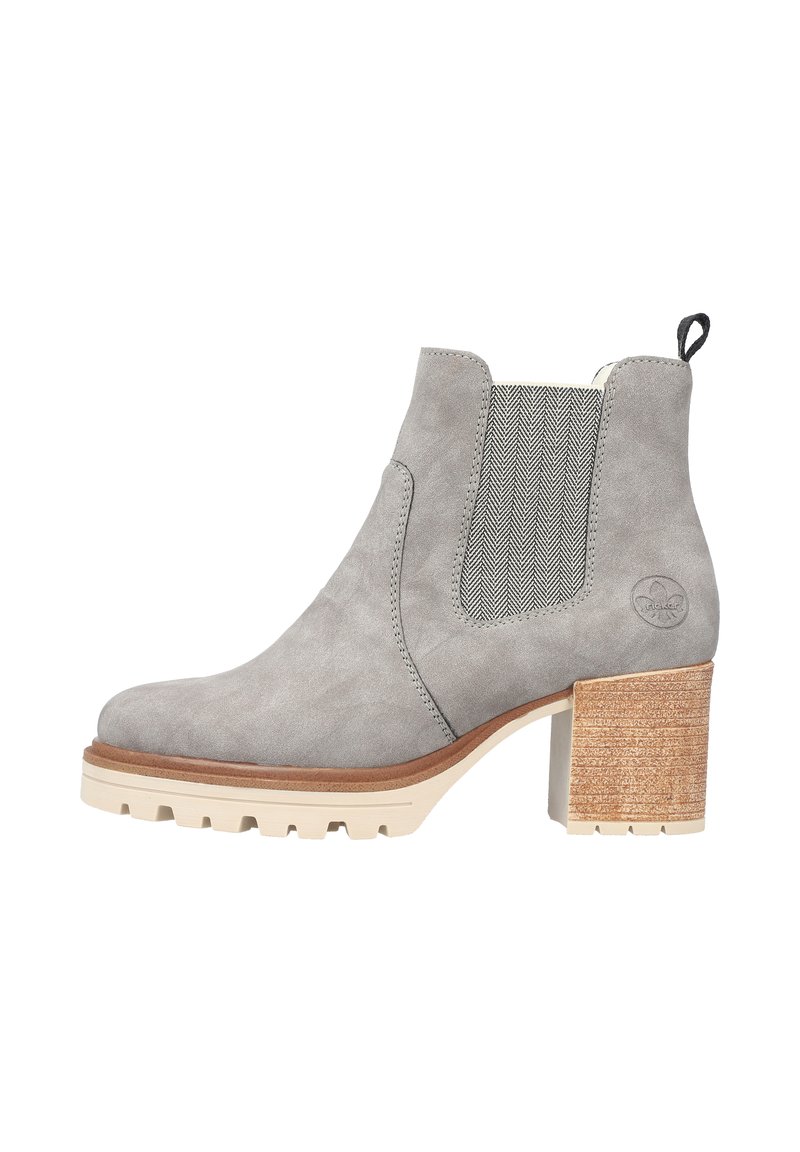 Bottine en suède gris clair avec un panneau latéral élastique texturé, un talon épais blanc et marron, et une languette à l'arrière.