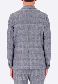 Blazer grigio a motivi con tessitura testurizzata, spacco singolo e polsini con due bottoni. Presenta un colletto strutturato e un design a griglia unico.