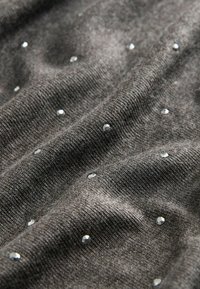 Grauer Strickstoff mit einer weichen Textur, der verstreute, reflektierende Strasssteine für zusätzlichen Detailschmuck auf der Oberfläche aufweist.