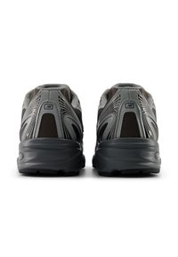 Γκρι αθλητικά παπούτσια με ύφασμα δικτυωτό και συνθετικό υλικό, με επενδυμένη σόλα, υφή και εμφανές λογότυπο στη φτέρνα.