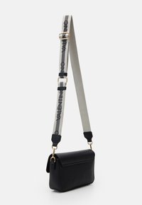 Bolsa de ombro preta em couro com formato retangular, apresentando uma alça cinza com o texto "Valentino" em preto, detalhes em dourado e fecho de aba.