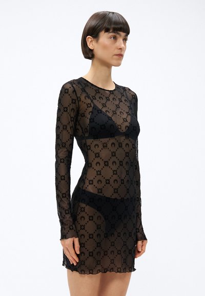 Čierne priesvitné šaty s dlhými rukávmi, zdobené kvetinovým vzorom a priliehavým strihom. Materiál je ľahký a polopriesvitný.