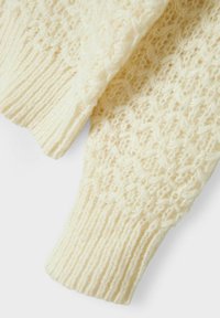 Strickpullover in Creme mit einem strukturierten Muster und einem gerippten Bündchen. Das weiche, flauschige Material sorgt für ein gemütliches Aussehen.