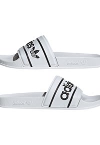 Vita slidesandaler med svarta ränder och svart "adidas"-logotyp. Texturerat syntetiskt övre och sula, med varumärkets emblem på sidan.